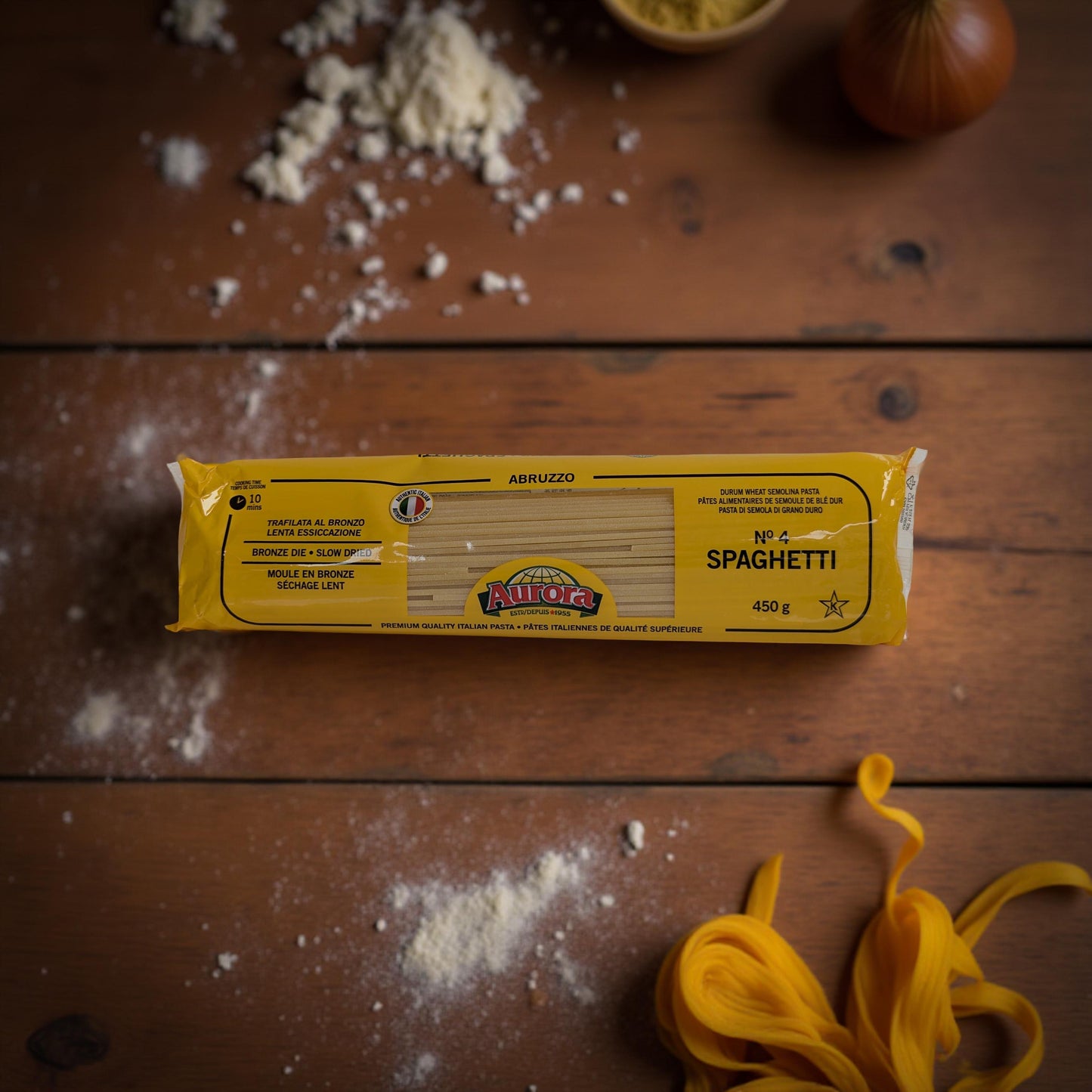 Alfio Spaghetti package on a wooden surface with uncooked spaghetti strands.