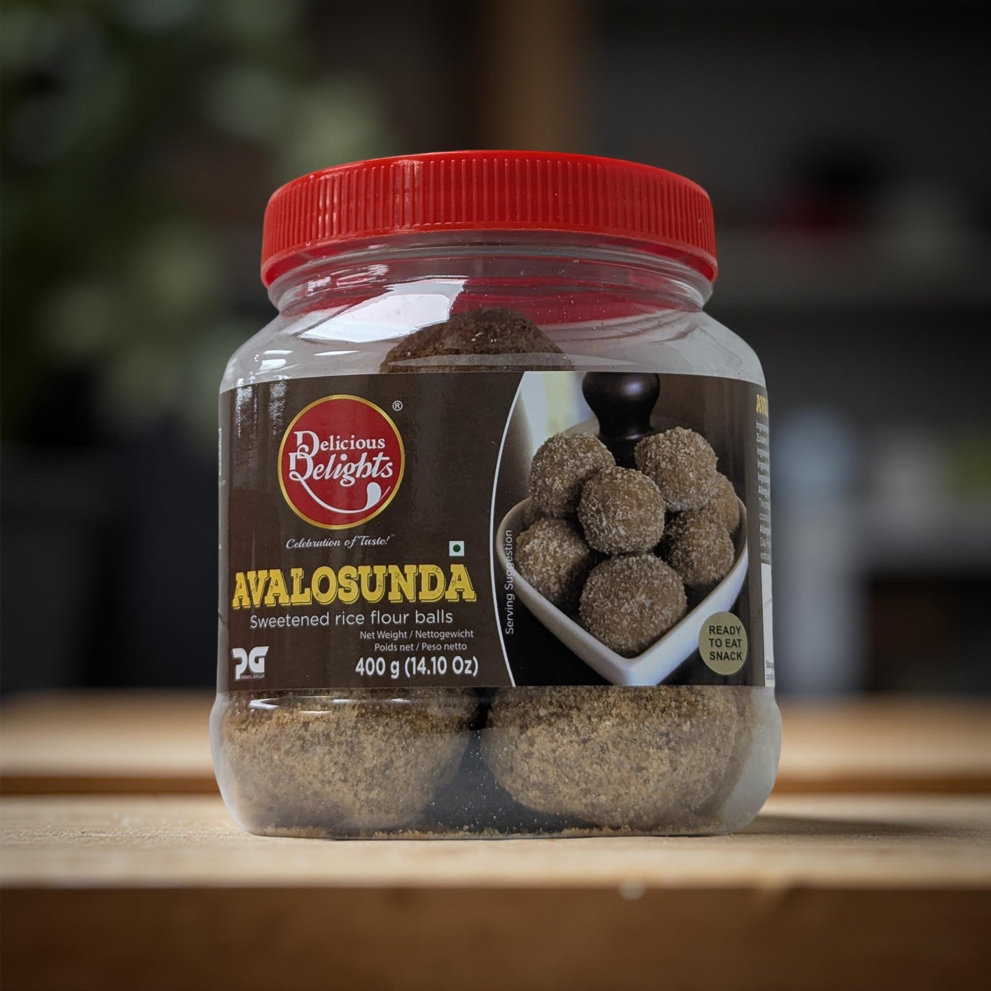 Jar of Avalosunda sweetened rice flour balls with a red lid on a wooden surface.