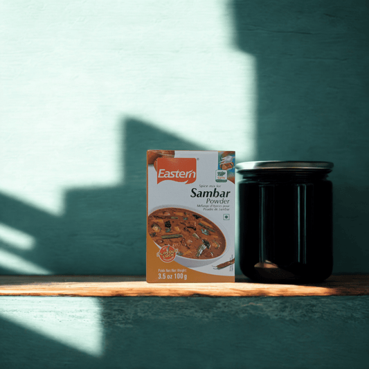 Box of Eastern Sambar Powder on a wooden surface with a green wall background