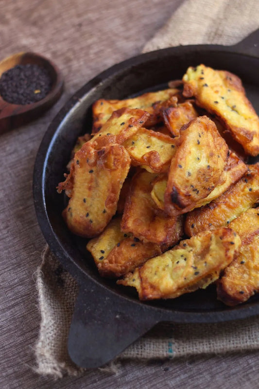 Fried food items in a black skillet on a rustic surface