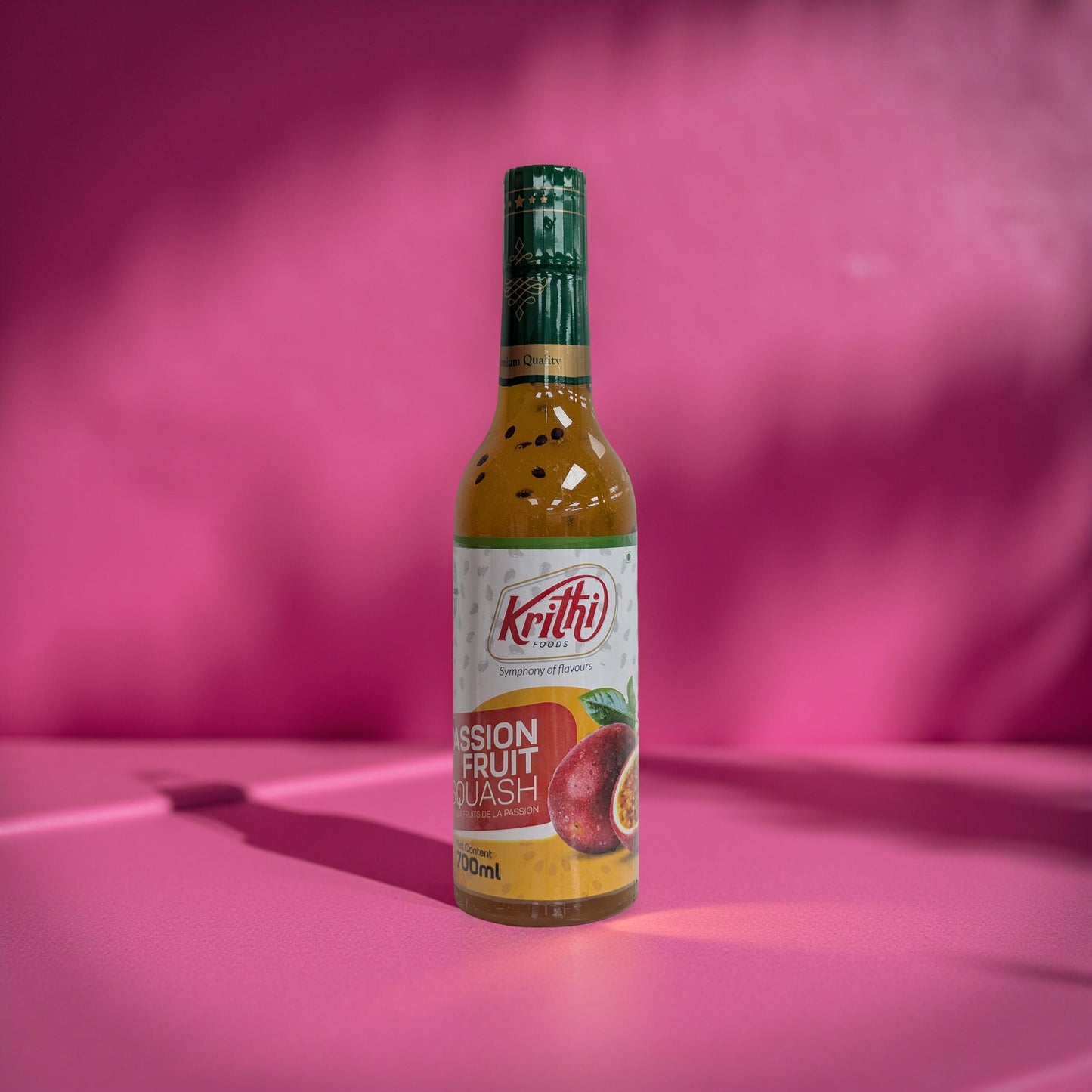 Bottle of Krithi Passion Fruit Crush on a pink background