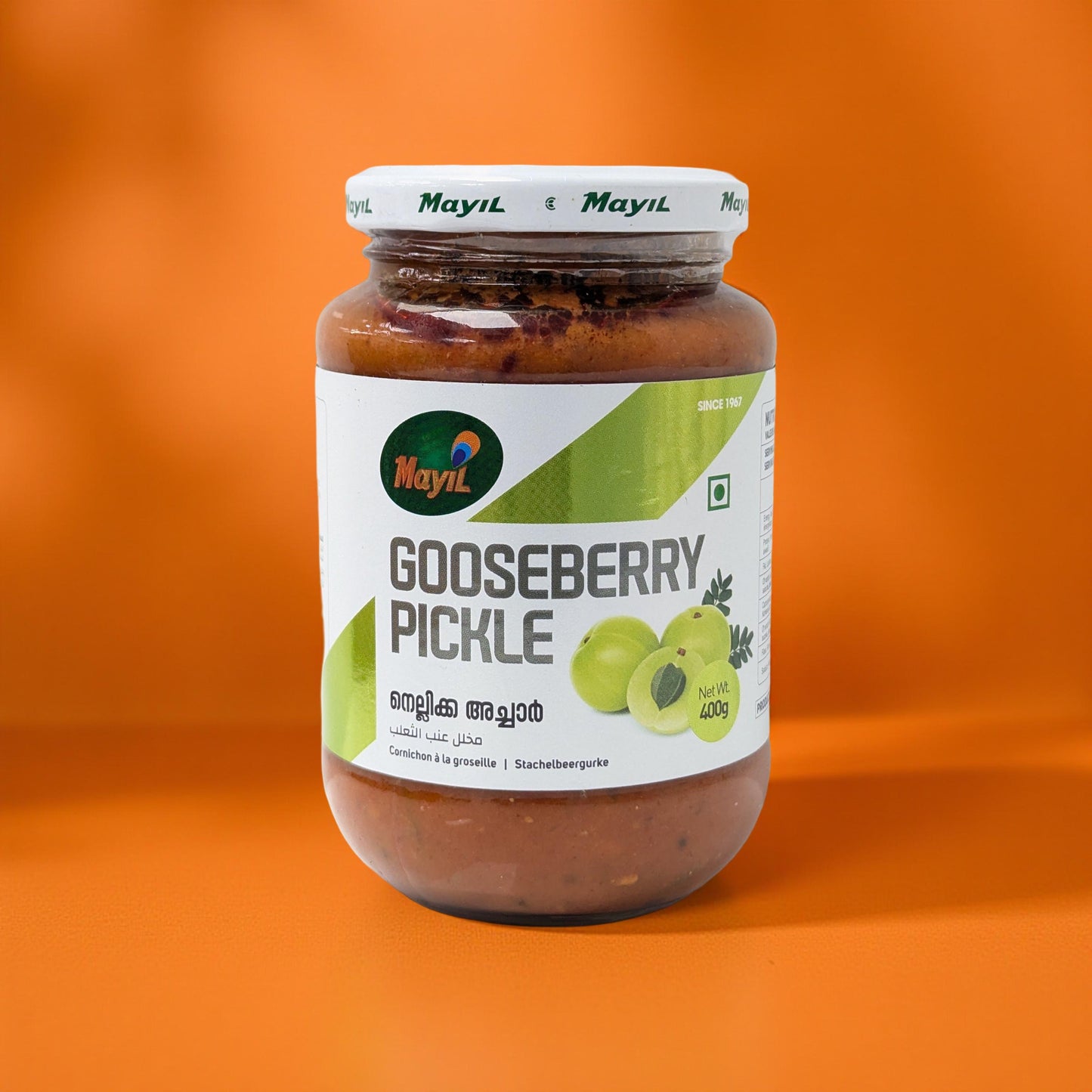 Jar of gooseberry pickle with a Mayil brand label on an orange background