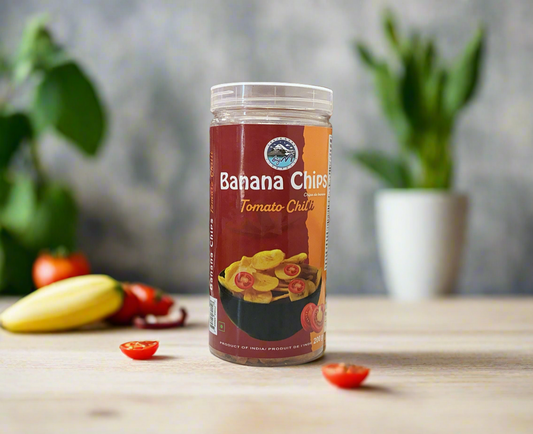 Canister of Banana Chips Tomato Chilli on a wooden surface with plants in the background