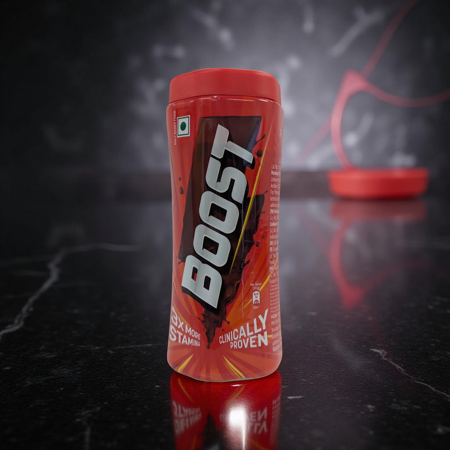 Boost energy drink container on a reflective black surface with a dark background