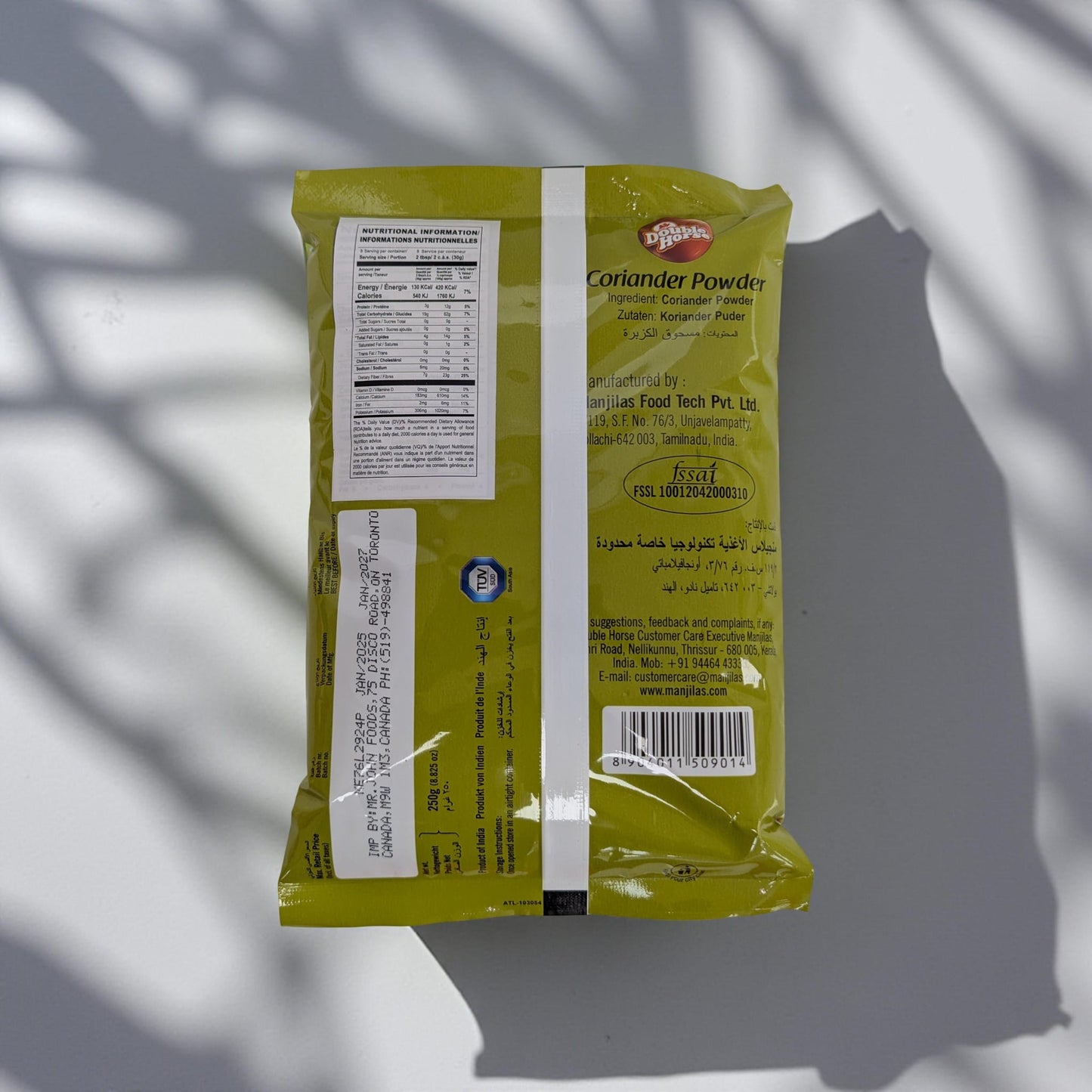 Yellow packet of coriander powder with text and a barcode on a gray background