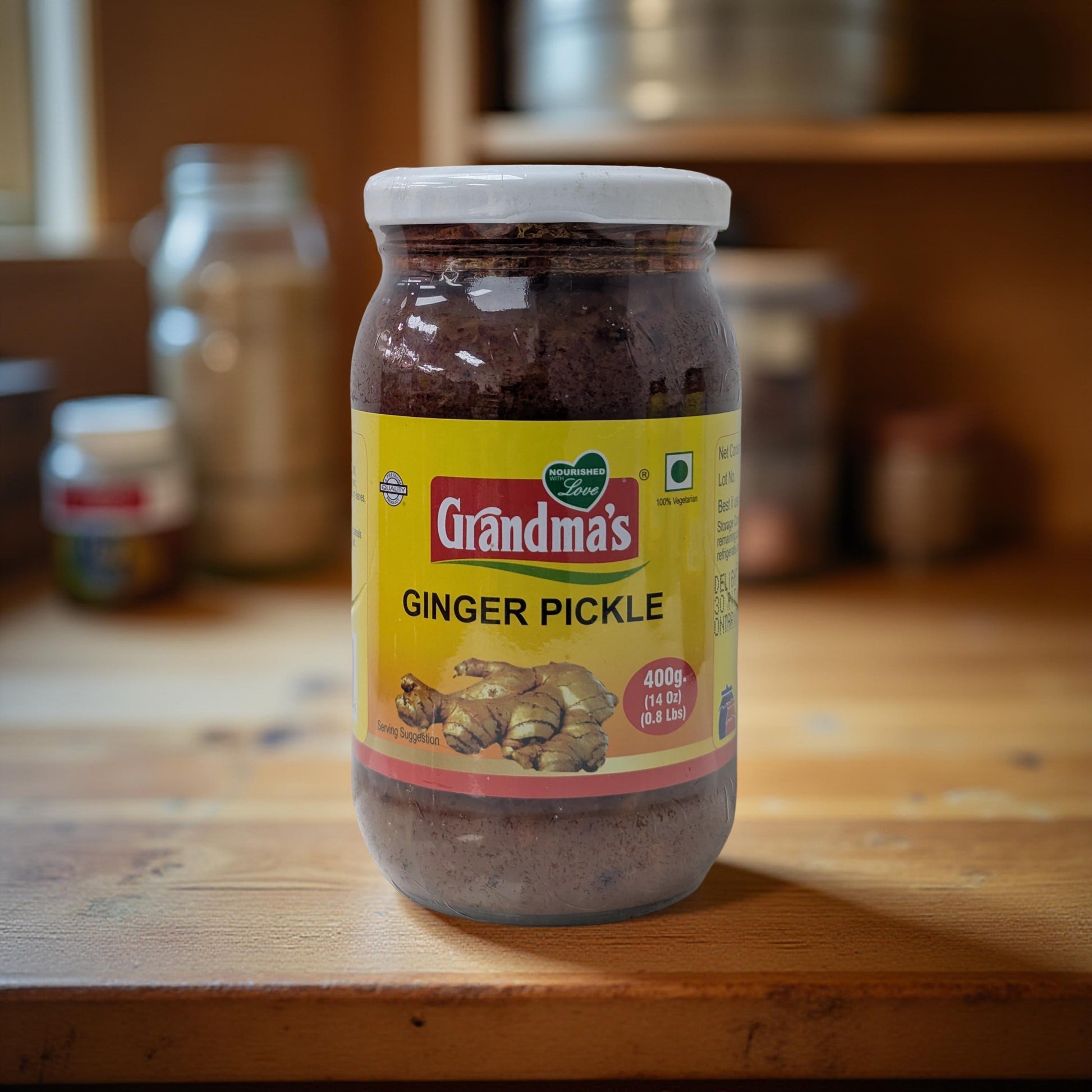 Jar of Grandma's Ginger Pickle on a wooden surface with blurred jars in the background