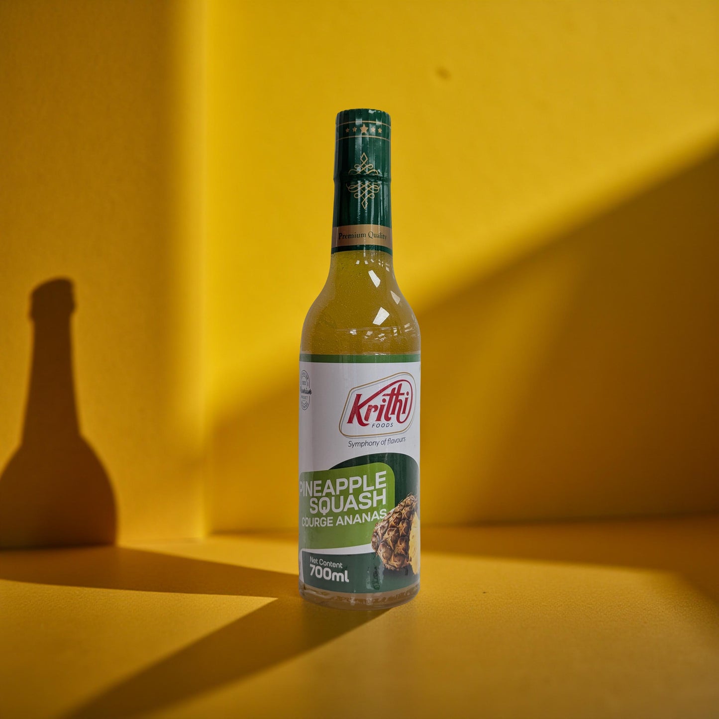 Bottle of Krithi Pineapple Squash on a yellow background