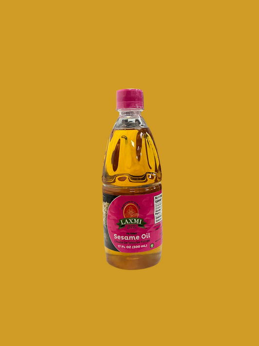 Bottle of Laxmi Sesame Oil on a mustard yellow background