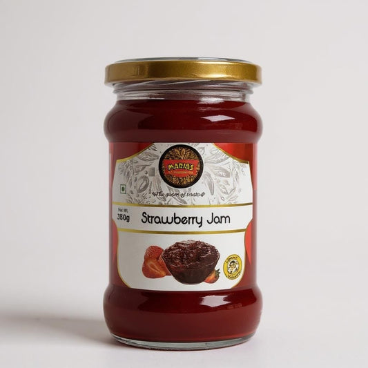 Jar of strawberry jam with a gold lid on a white background