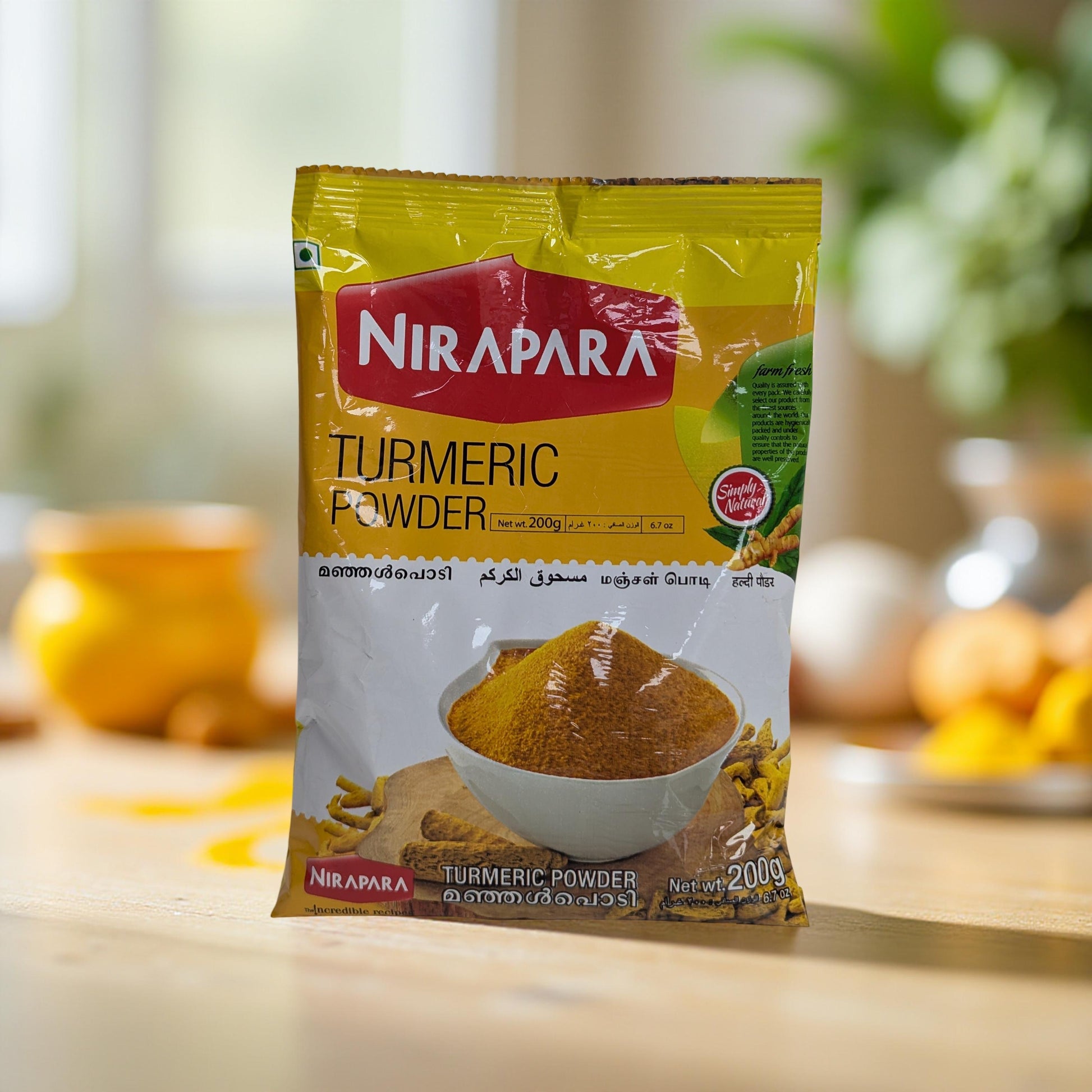 Nirapara Turmeric Powder packet on a wooden surface with a blurred background