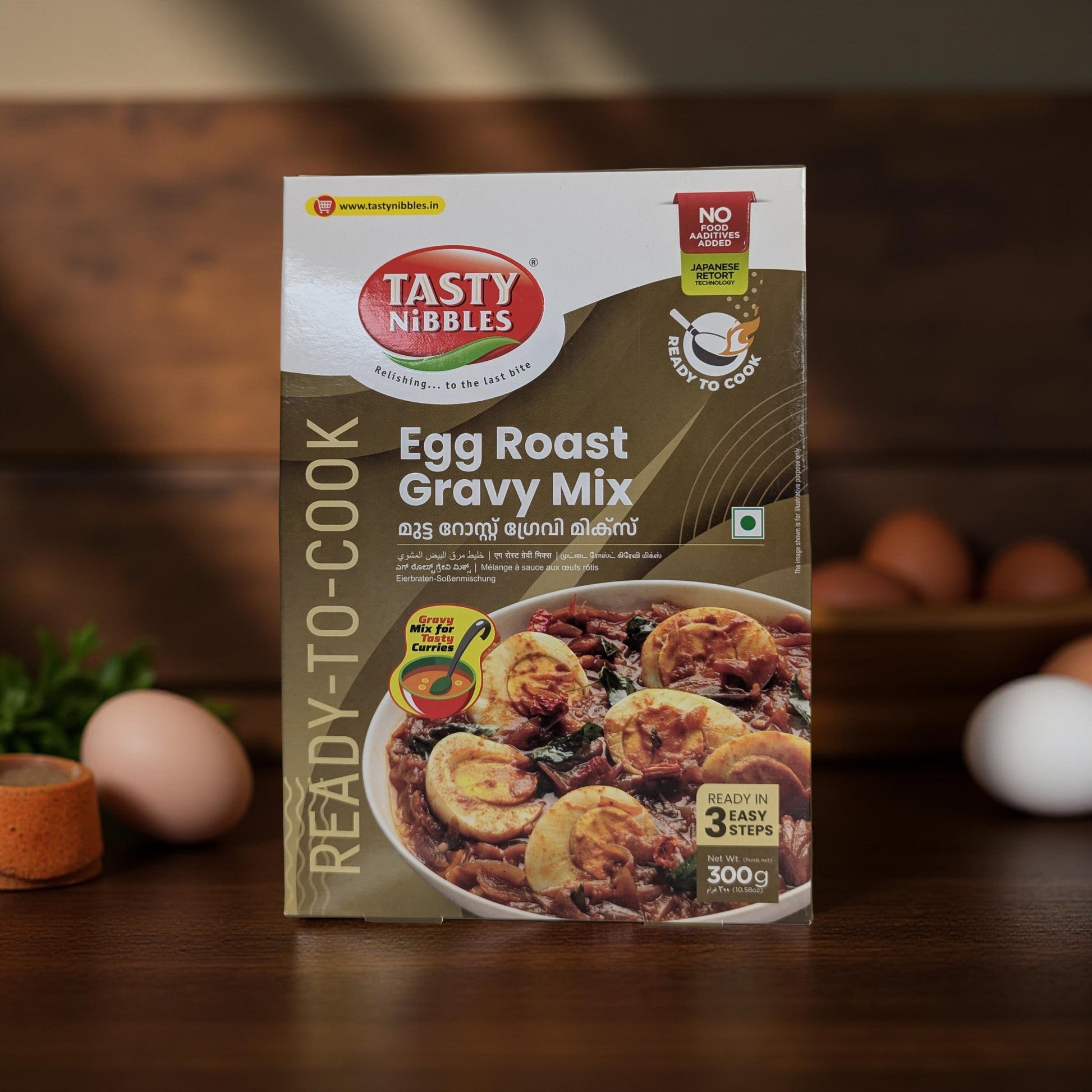 Tasty Nibbles Egg Roast Gravy Mix packaging on a wooden surface with eggs and herbs in the background.
